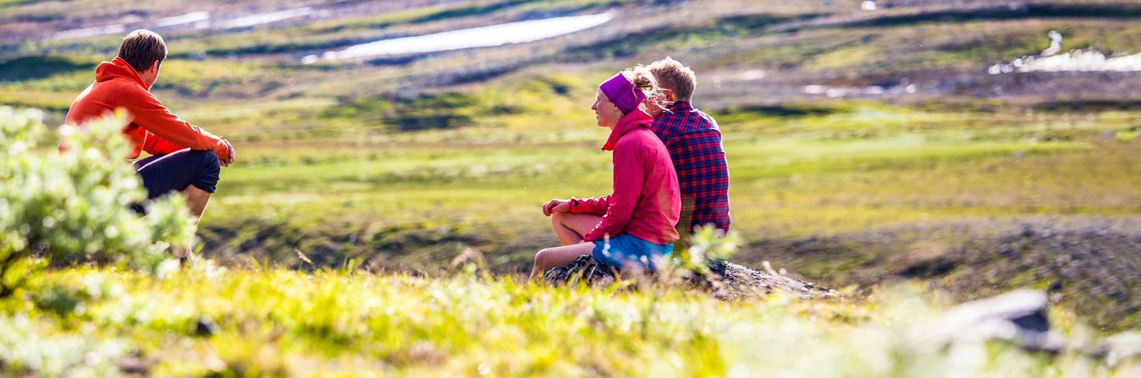 Tre vänner tar en paus under fjällvandring