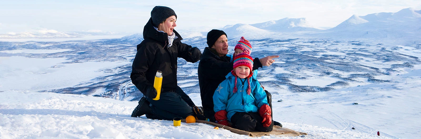 Barnfamilj äter fika i snön