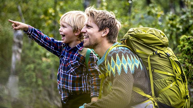 Pojke och pappa på upptäcktsfärd i skogen