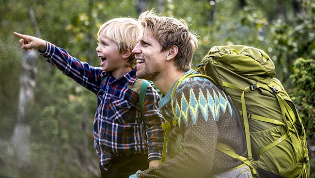 Pojke och pappa på upptäcktsfärd i skogen
