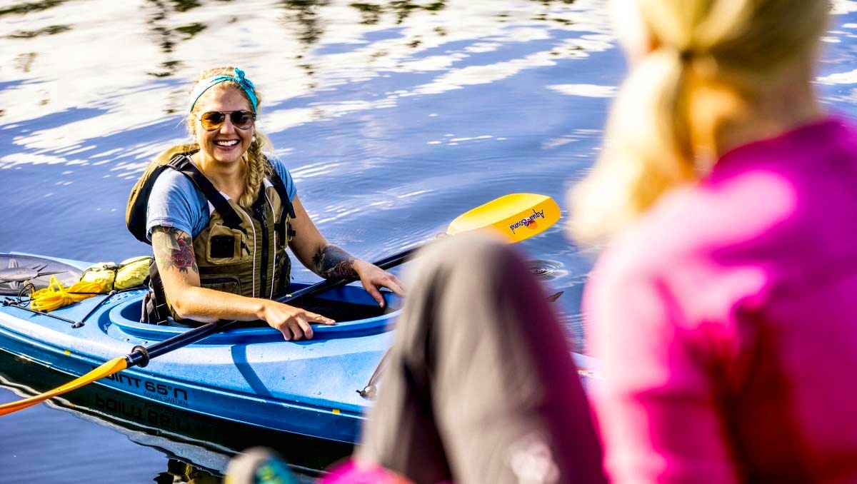 Tjej med solglasögon i kajak