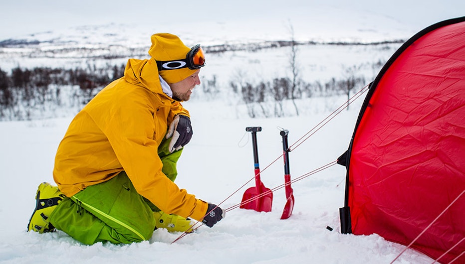 Man slår upp tält på vinter