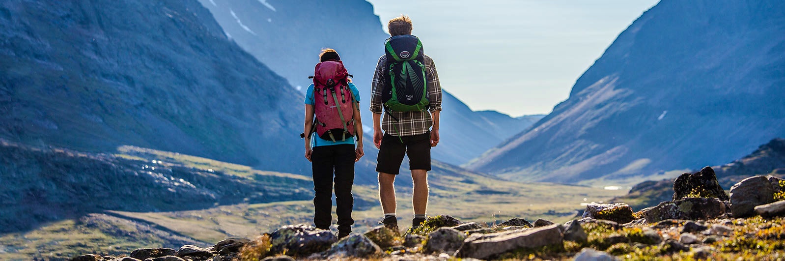 Fjälluffande vänner med ryggsäckar