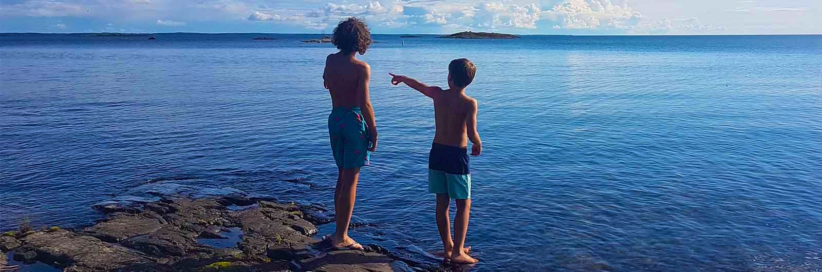 Två pojkar badar i havet