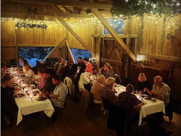 En grupp människor sitter tillsammans runt dukade bord.