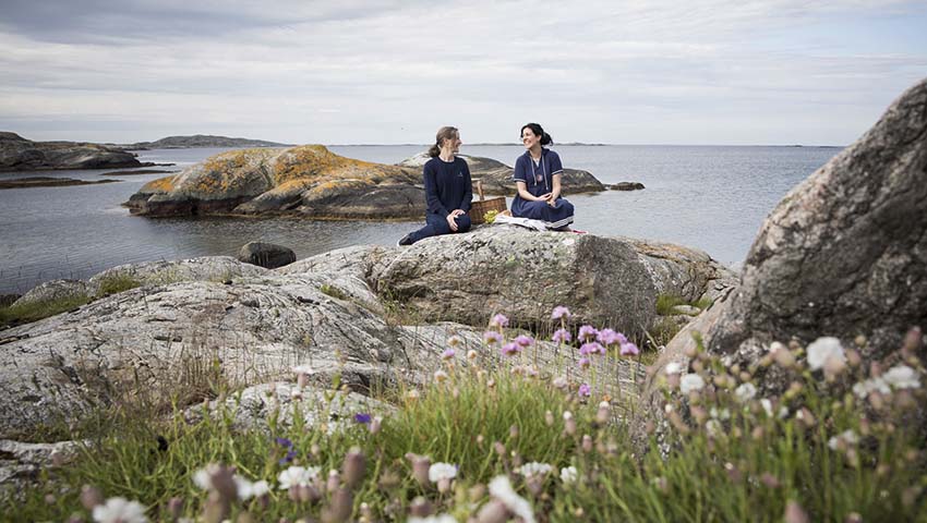 Två kvinnor sitter på klippa i Göteborgs södra skärgård