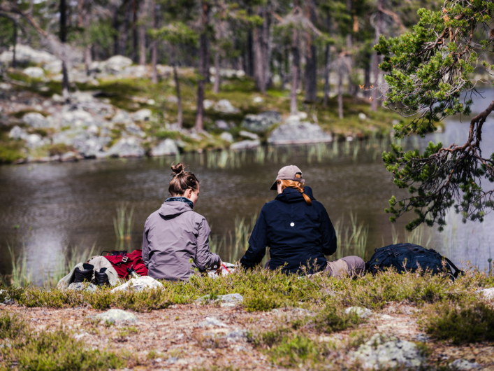 Två kvinnor sitter vid sjön Rogen.