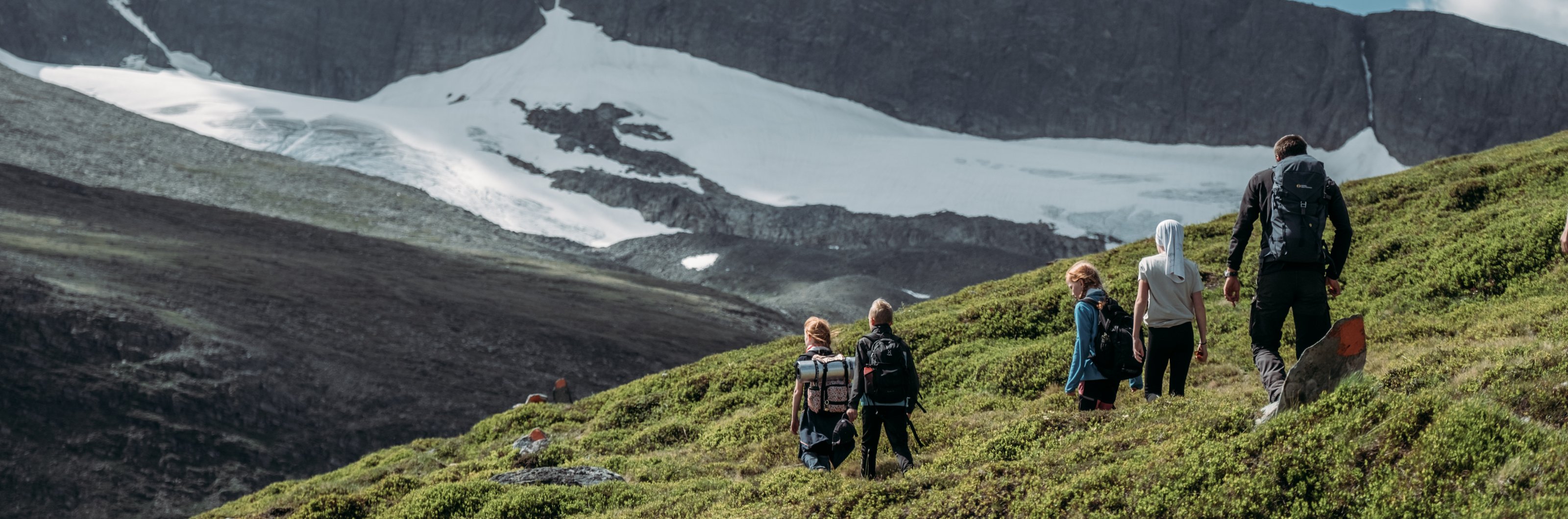 En familj vandrar i fjällen vid Helags.