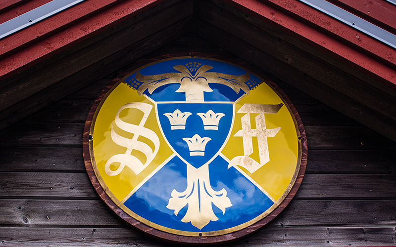 Närbild på Svenska Turistföreningens emblem i gult och blått.