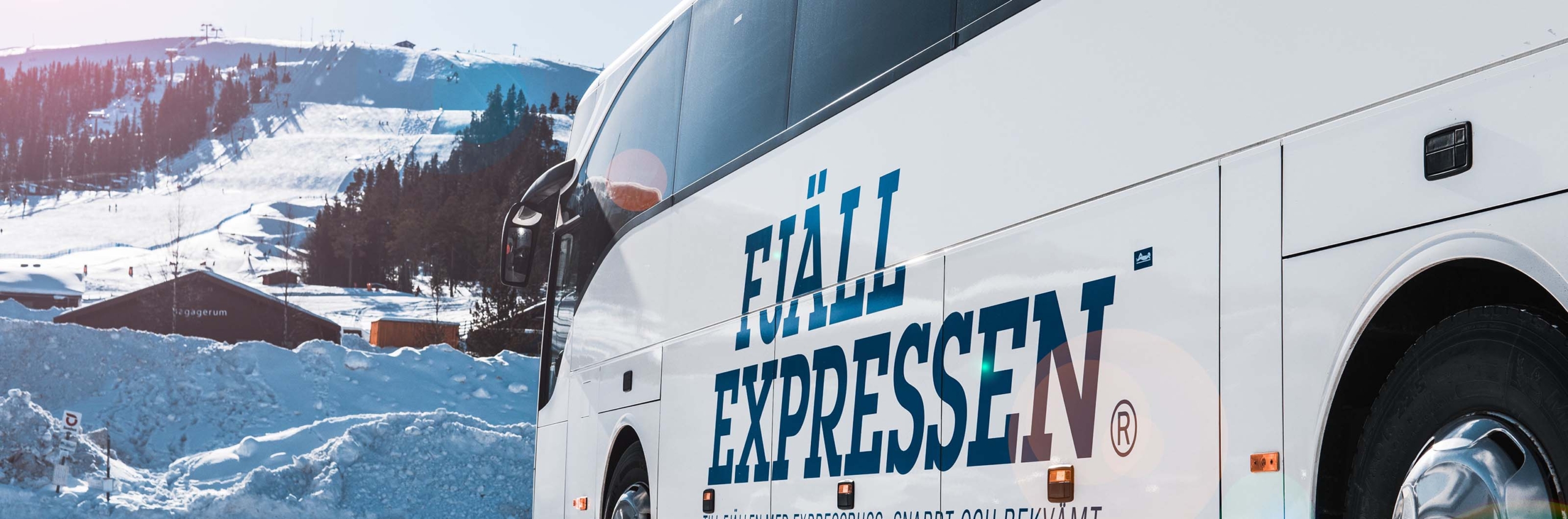 En buss parkerad framför en skidbacke.