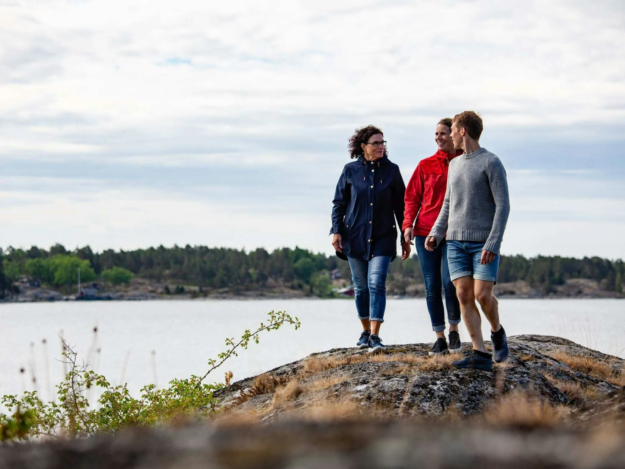 Tre personer står på en klippa i Stockholms skärgård.