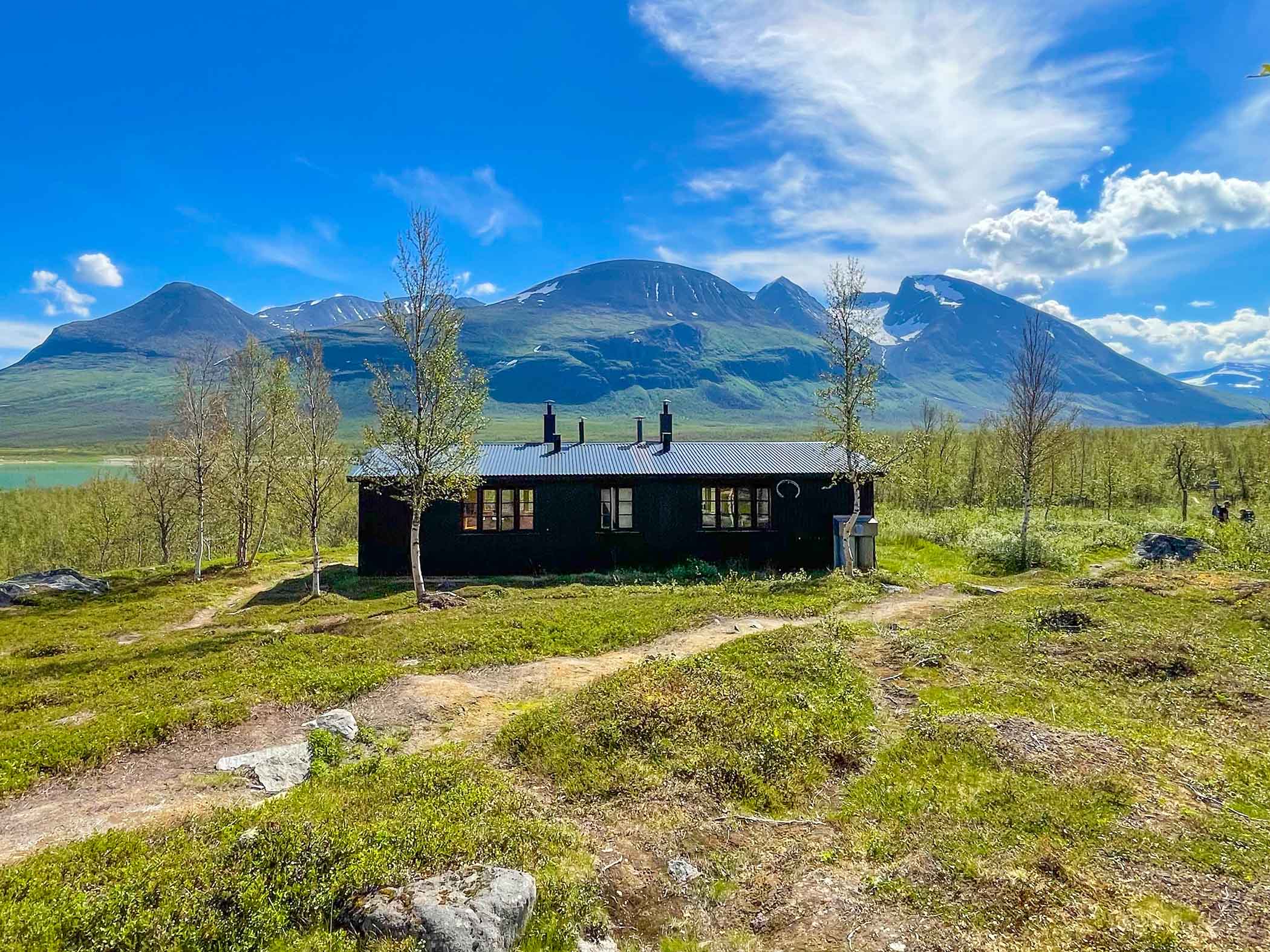 Akka fjällstuga med berg i bakgruden. 