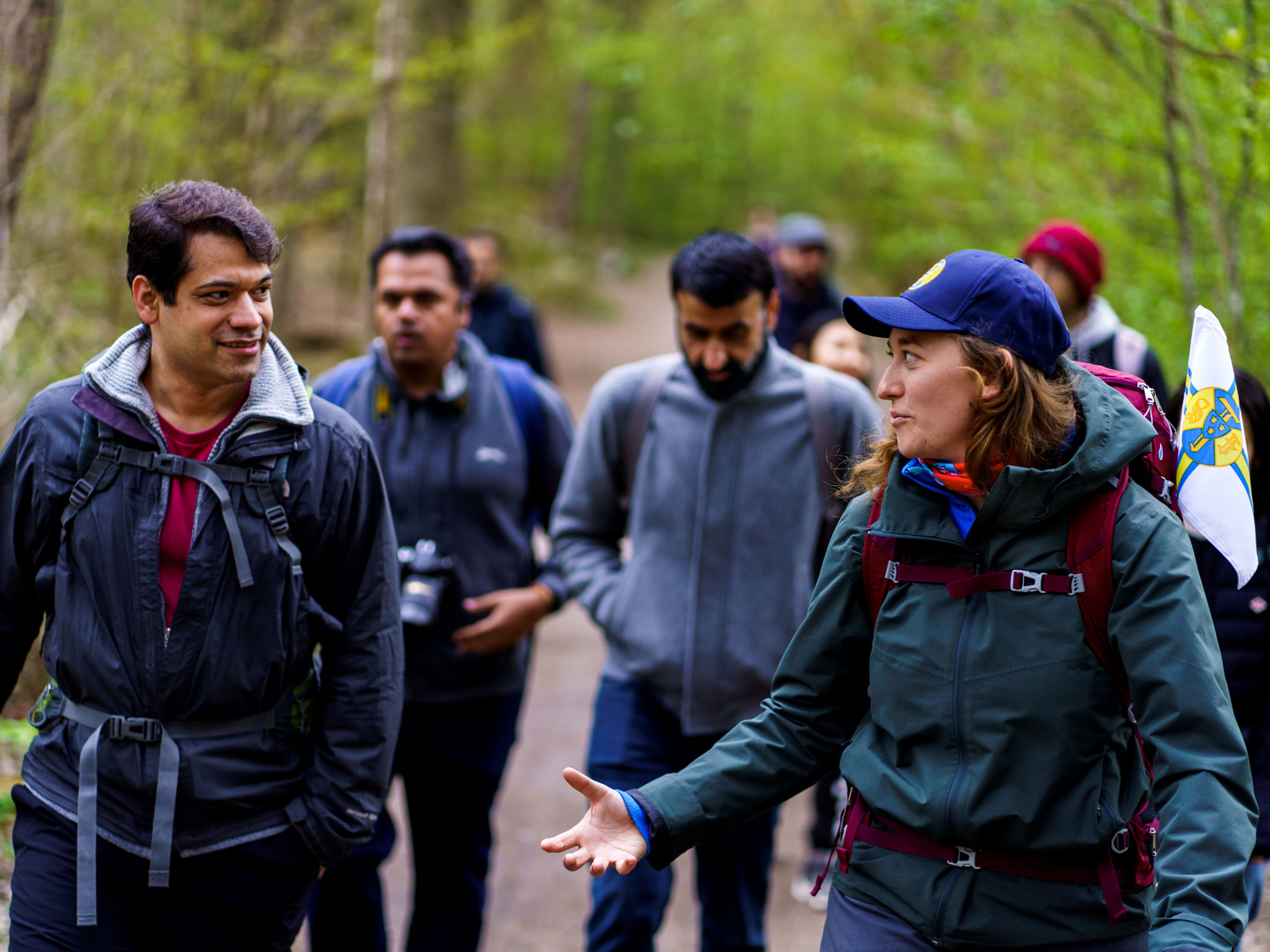 En vandringsledare går med en grupp personer i skogen.