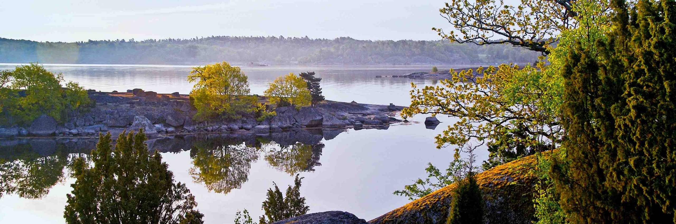 Vy över ett stilla hav med kobbar och skär längs Blekingeleden.