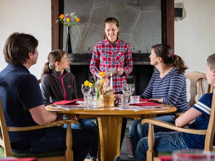 En barnfamilj sitter vid ett bord i Vålådalen Fjällstations matsal.