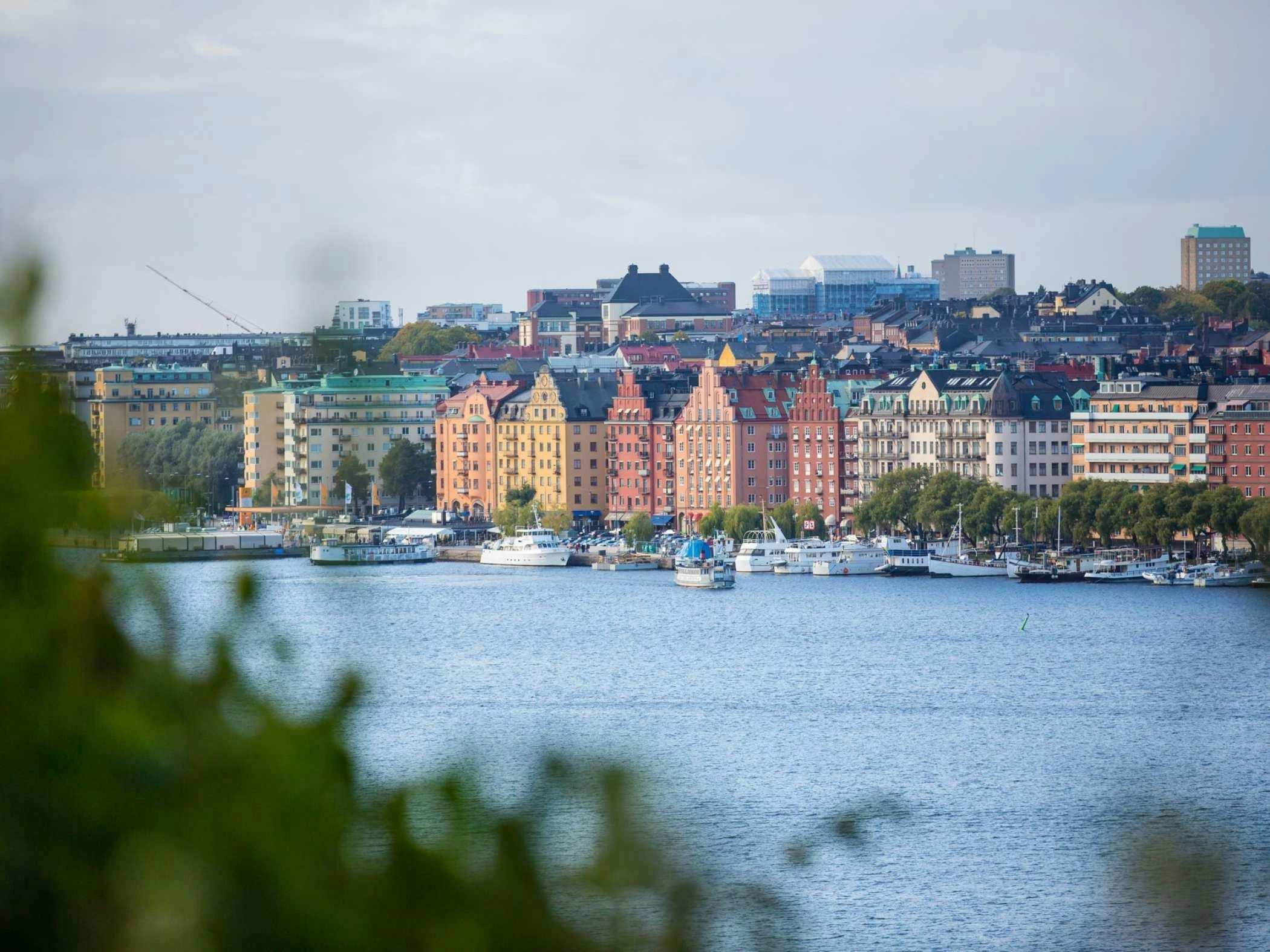 Stadssiluett över Stockholm med hus och vatten.
