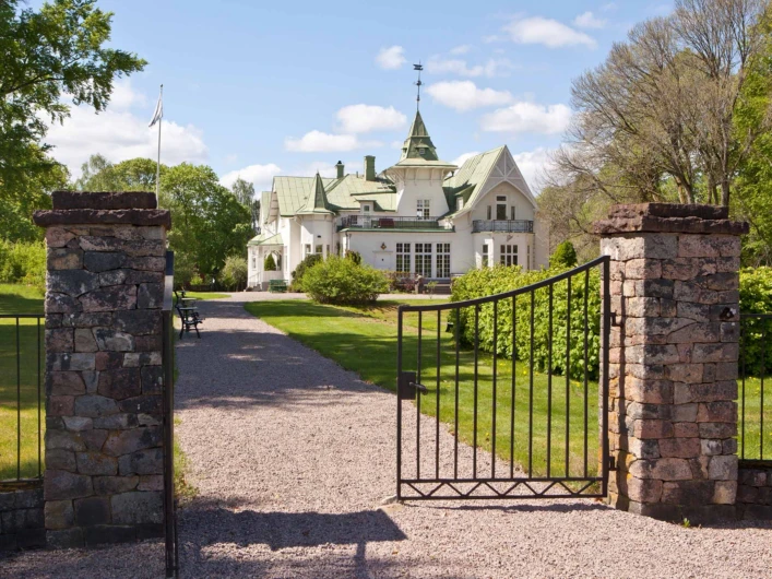 STF Villa Gransholm och en öppen grind i förgrunden.