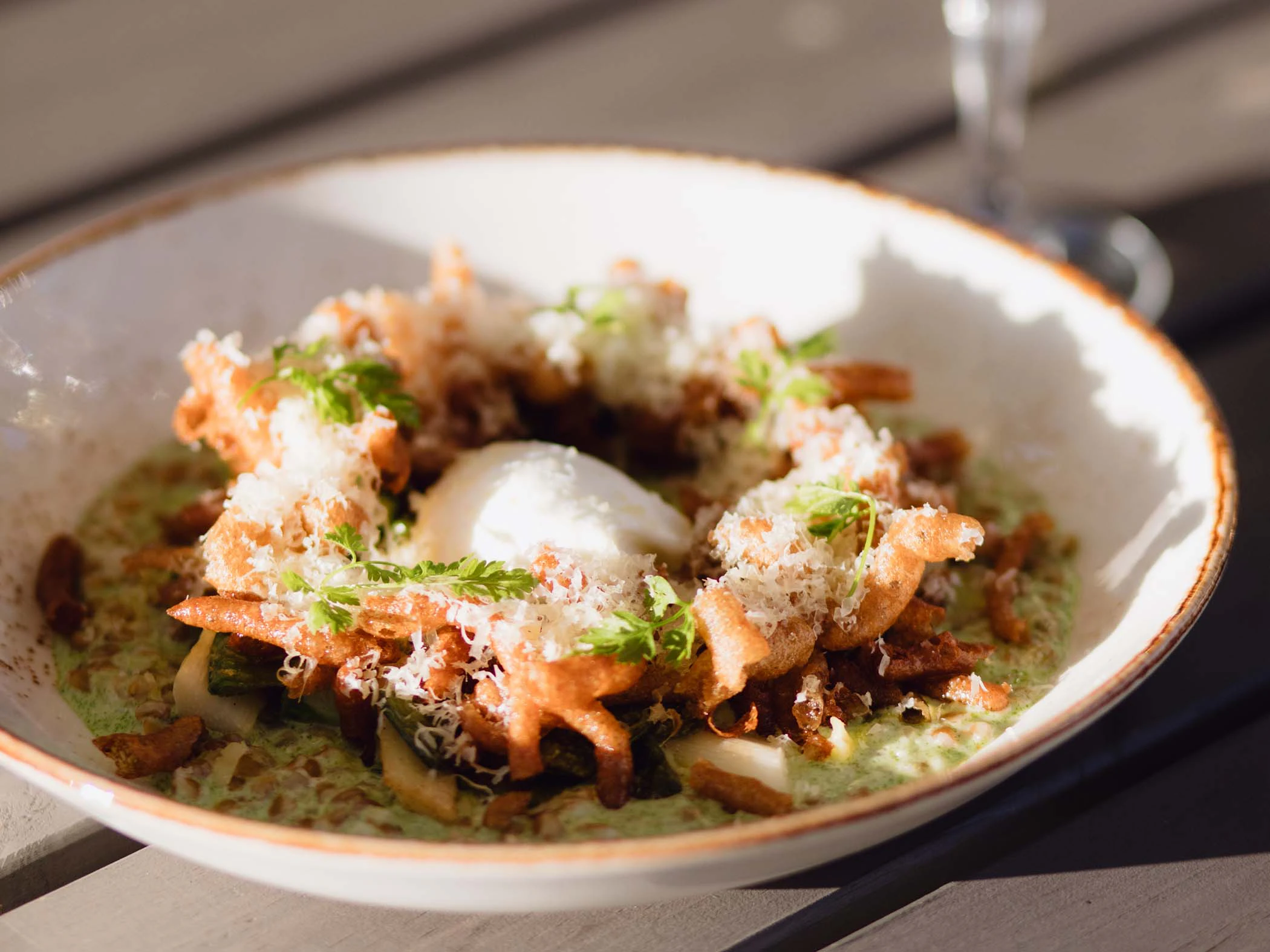 Vi tallrik med mat toppad med riven ost och örter, serverad i varmt ljus