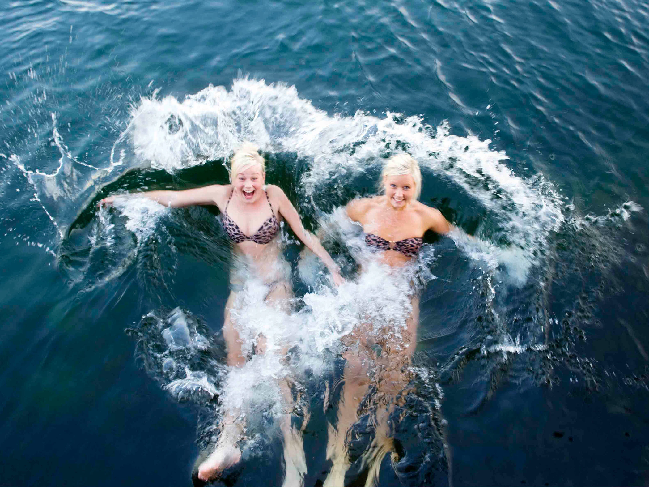 Två tjejer badar i havet.