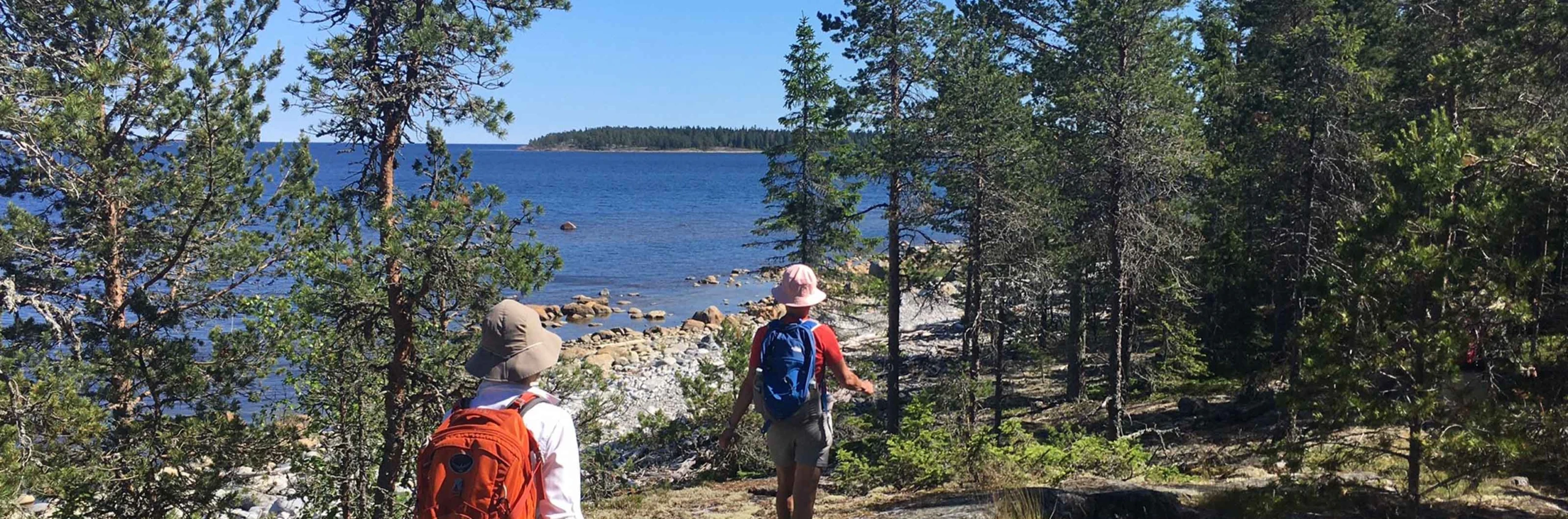 Två personer vandrar längs kusten i Umeå.