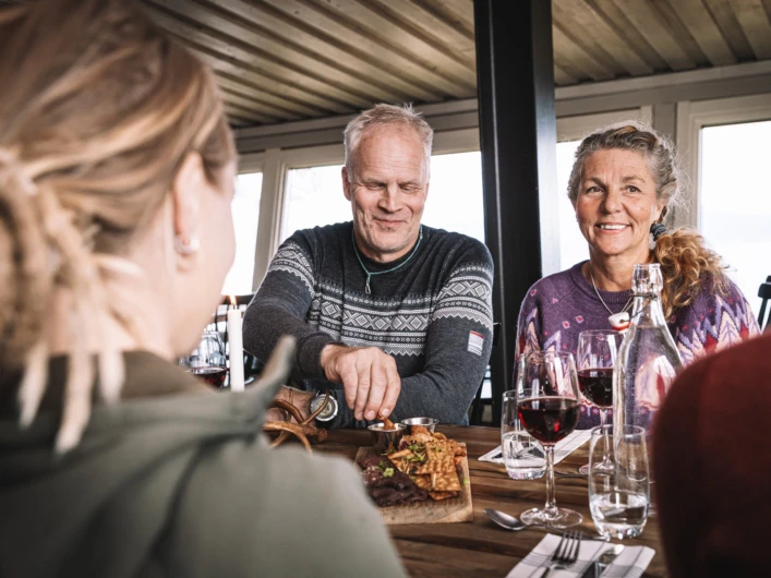 En grupp människor som sitter runt ett träbord.